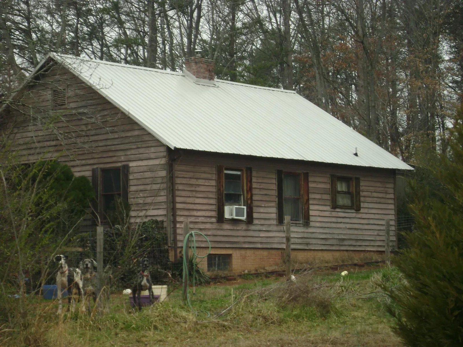 White metal roof on an old wood sided farmhouse, from a Asphalt Shingle Roof Repair job in Lamar